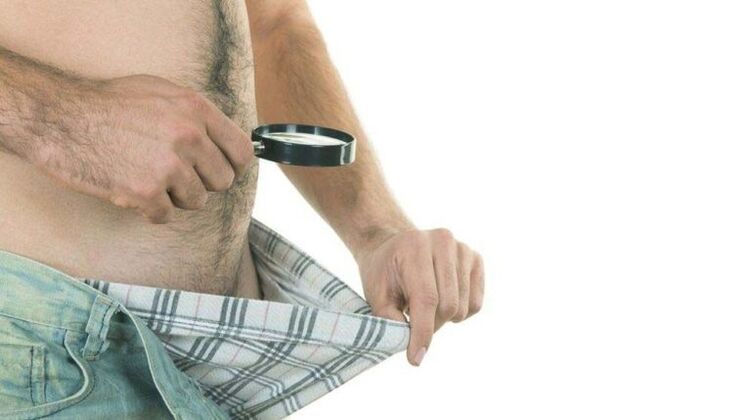 un homme regarde dans ses sous-vêtements et pense à l'agrandissement du pénis avec du soda